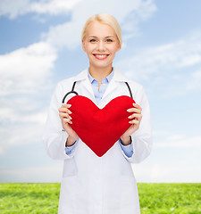 Image showing smiling female doctor with heart and stethoscope