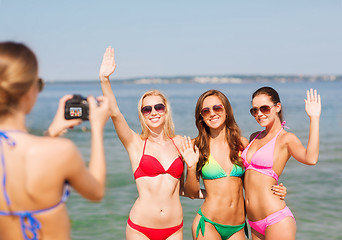 Image showing group of smiling women photographing on beach