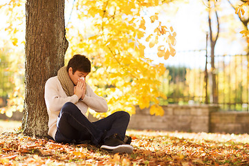 Image showing smiling young man with tablet pc in autumn park