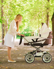 Image showing happy mother with stroller in park