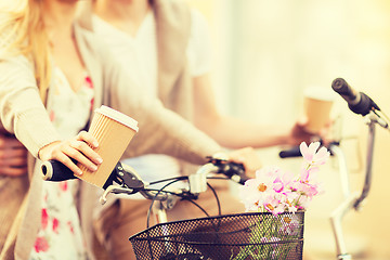 Image showing couple holding coffee and riding bicycle