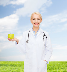 Image showing smiling female doctor with green apple