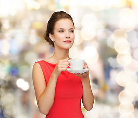 Image showing smiling woman in red dress with cup of coffee