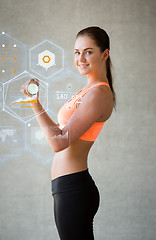 Image showing smiling woman with dumbbells in gym