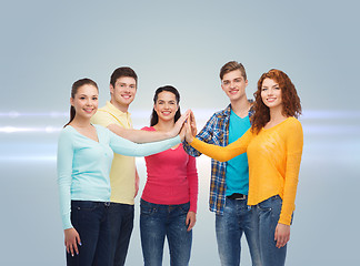 Image showing smiling teenagers making high five