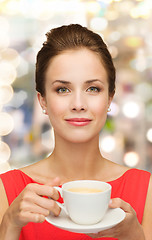 Image showing smiling woman in red dress with cup of coffee