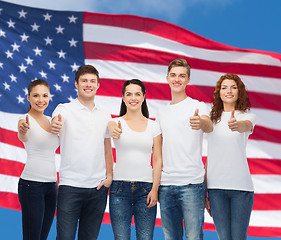 Image showing smiling teenagers in t-shirts showing thumbs up