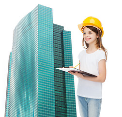 Image showing smiling little girl in hardhat with clipboard