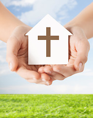 Image showing close up of hands and paper house with cross