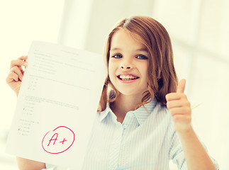 Image showing smiling little student girl with test and A grade