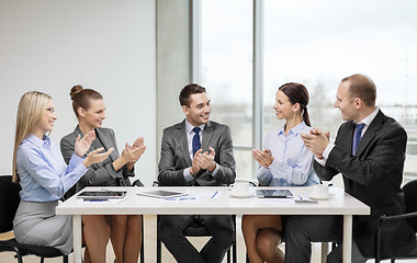 Image showing business team with laptop clapping hands