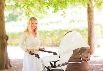 Image showing happy mother with stroller in park