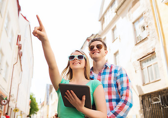Image showing smiling couple with tablet pc in city