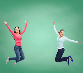 Image showing smiling young women jumping in air