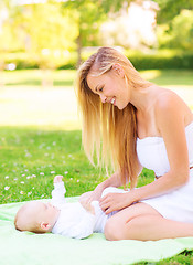 Image showing happy mother lying with little baby on blanket