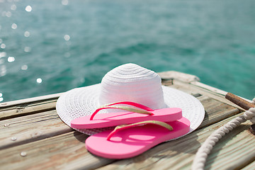 Image showing close up of hat and slippers at seaside