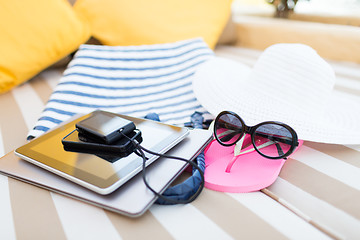 Image showing close up of tablet pc and smartphone on beach