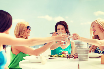 Image showing smiling girls looking at tablet pc in cafe