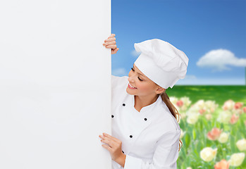 Image showing smiling female chef with white blank board