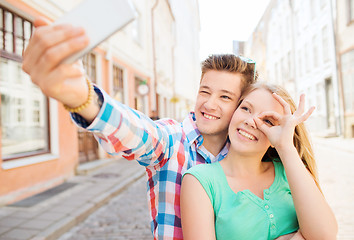 Image showing smiling couple with smartphone in city