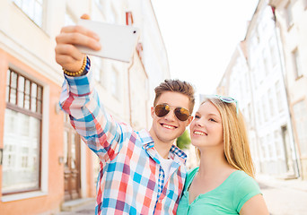 Image showing smiling couple with smartphone in city