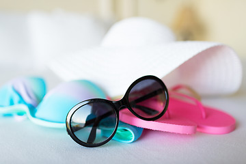 Image showing bikini top, hat, flip-flop and sunglasses