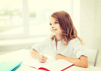 Image showing student girl writing in notebook at school