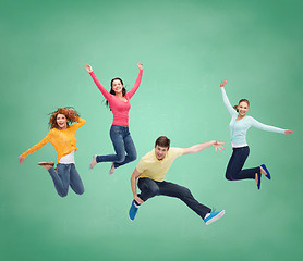 Image showing group of smiling teenagers jumping in air