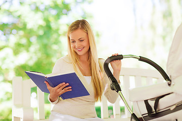 Image showing happy mother with book and stroller in park