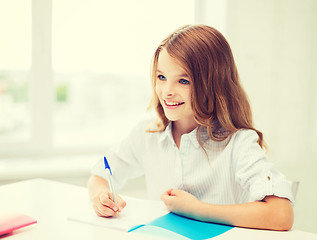 Image showing student girl writing in notebook at school