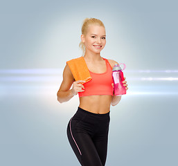 Image showing smiling sporty woman with water bottle and towel