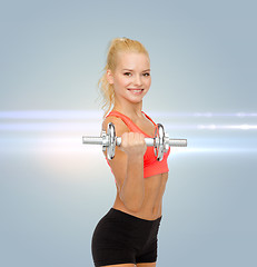 Image showing young sporty woman with heavy steel dumbbell