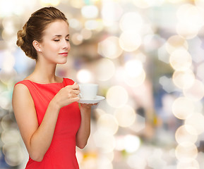 Image showing smiling woman in red dress with cup of coffee