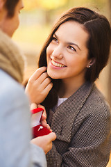 Image showing close up of smiling couple with gift box in park