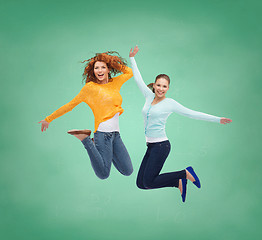 Image showing smiling young women jumping in air