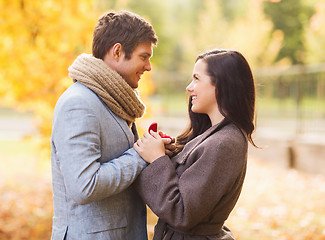 Image showing close up of smiling couple with gift box in park