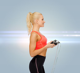 Image showing smiling sporty woman with skipping rope