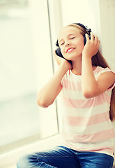 Image showing little girl with headphones at home