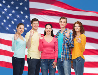 Image showing group of smiling teenagers over american flag