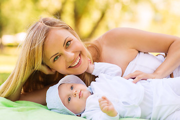 Image showing happy mother lying with little baby on blanket