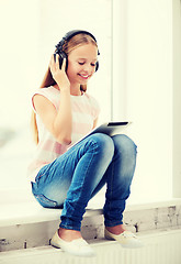 Image showing girl with tablet pc and headphones at home