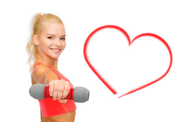 Image showing smiling beautiful sporty woman with dumbbell