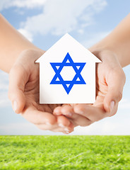 Image showing close up of hands holding house with star of david