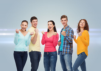 Image showing group of smiling teenagers showing triumph gesture
