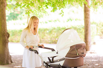 Image showing happy mother with stroller in park