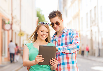 Image showing smiling couple with tablet pc in city