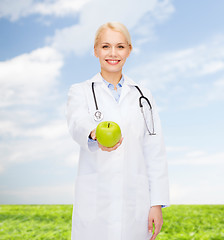 Image showing smiling female doctor with green apple