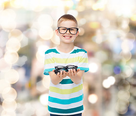 Image showing smiling boy in eyeglasses holding spectacles