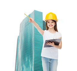 Image showing smiling little girl in hardhat with clipboard