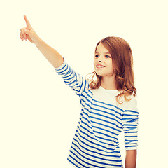 Image showing smiling girl pointing at virtual screen